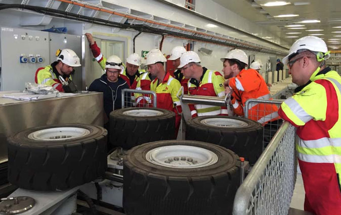 Seven men looking at a cable hauler